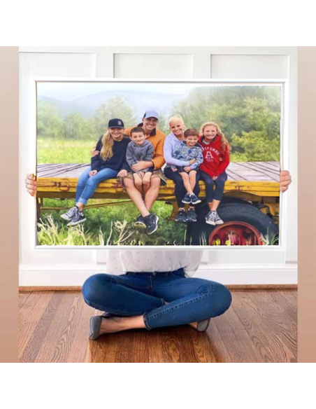 Woman holding up an oil painting made from an outdoor family photo